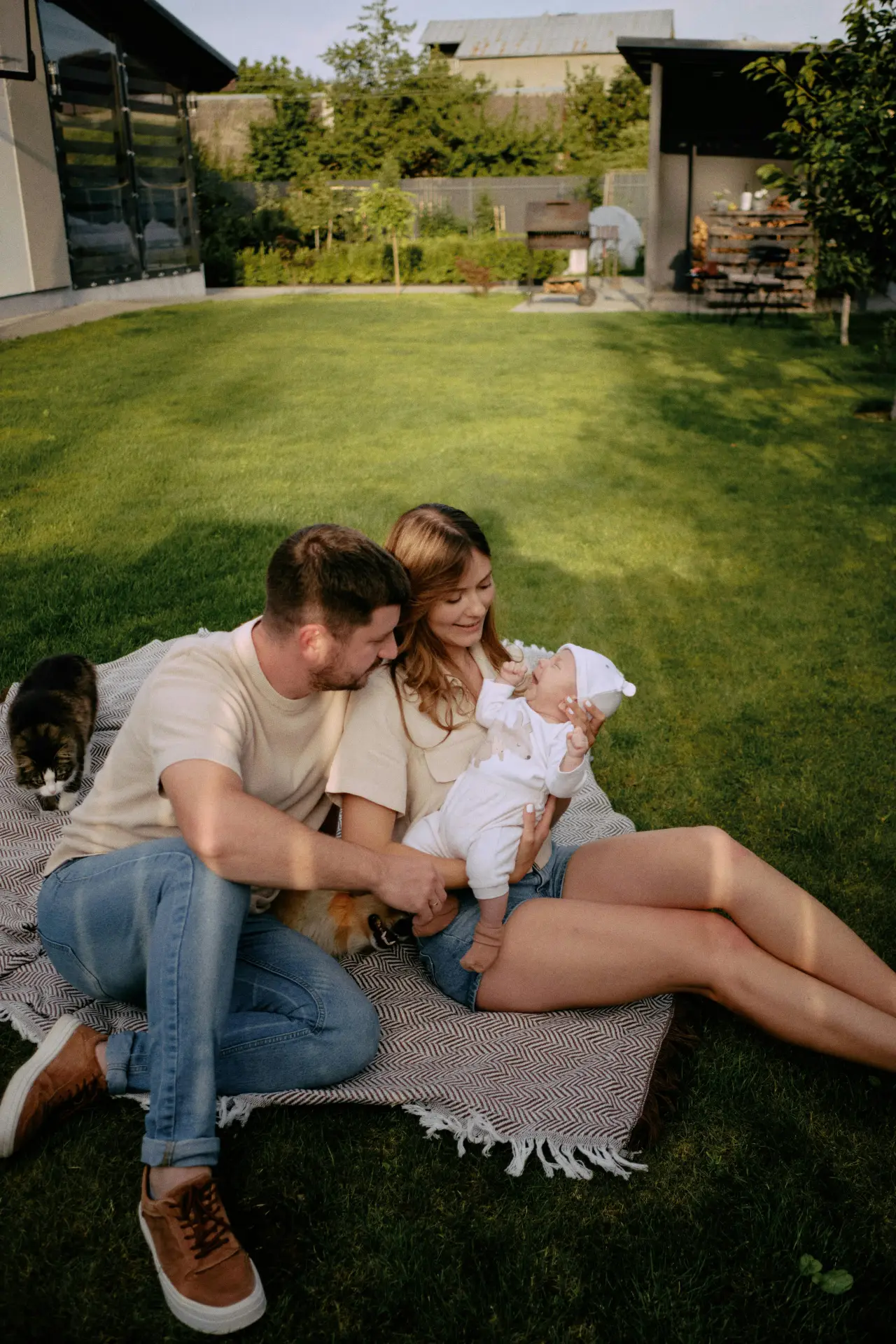 Ung familie med katt i bakgården på en solrik dag