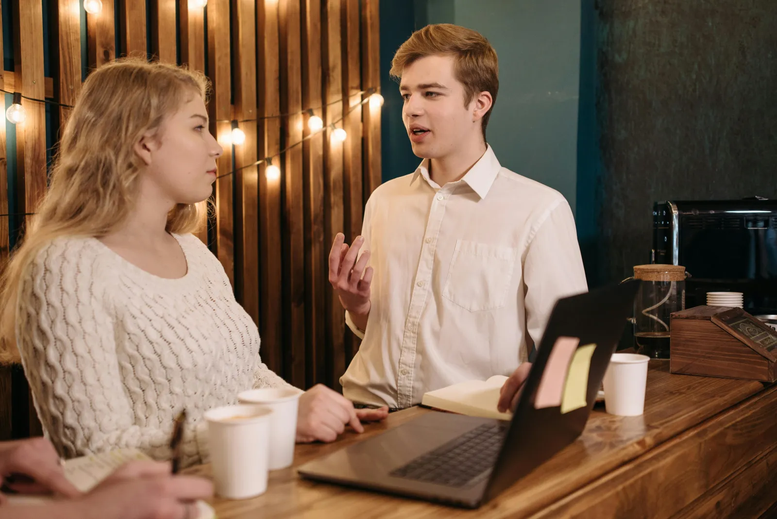 To personer i et uformelt møte ved et trebord med dokumenter